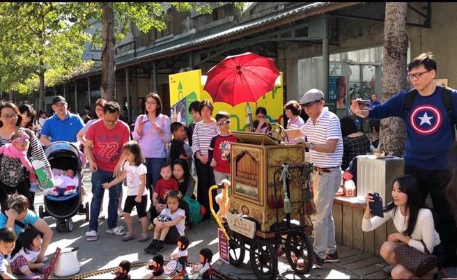 新北市文化局初五邀请街头艺人曾熯明于斩龙山遗址文化公园进行德国手摇管风琴演奏，吸引大小朋友同乐。（新北市文化局提供）