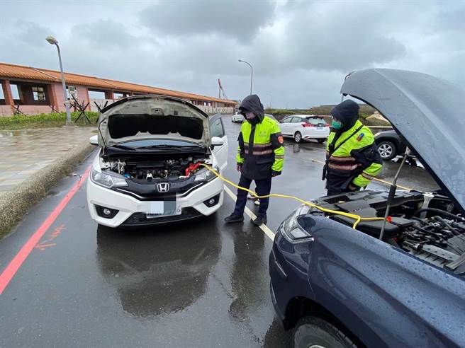 萬華男買完漁貨車拋錨在竹圍漁港，大園警發現立即冒雨幫接電助解危。(警方提供／蔡依珍桃園傳真)
