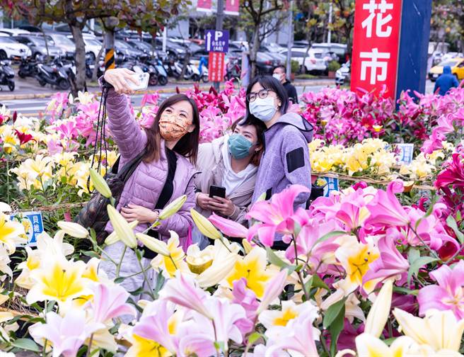 农历新年即将到来，虽然近日本土疫情升温，30日小年夜台北花市仍涌进大批人潮，有民眾开心和路边鲜花自拍。（罗永铭摄）