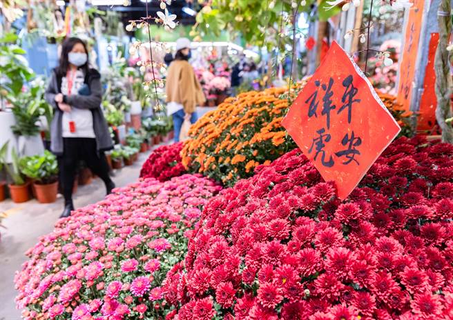 农历新年即将到来，在小年夜这天，各家摊商都摆出精美的新年饰品、花饰等，整个市场瀰漫着浓浓的新春喜气。（罗永铭摄）