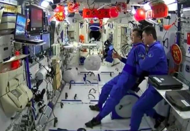 贴春联秀书法，大陆太空人首次在太空过年。（央视截图）