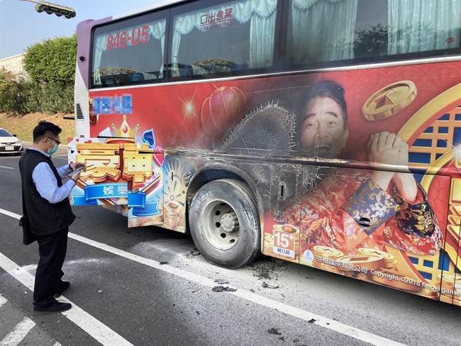 一輛客運輪胎突冒煙，消防人員趕緊到場處理。（讀者提供／洪靖宜高雄傳真）