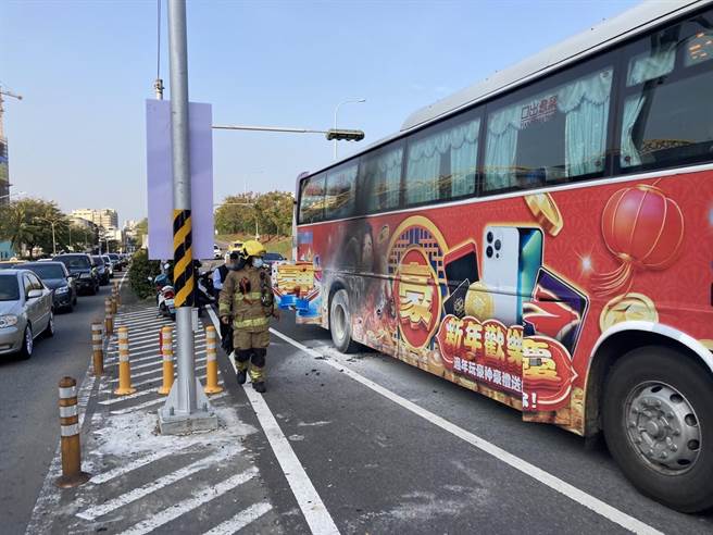 一輛客運輪胎突冒煙，消防人員趕緊到場處理。（讀者提供／洪靖宜高雄傳真）