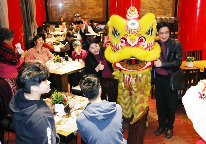 31日农历年除夕夜，不少家庭选择在台北圆山饭店围炉吃年夜饭，民眾争相与舞狮合影并摸狮头分享好彩头。（姚志平摄）