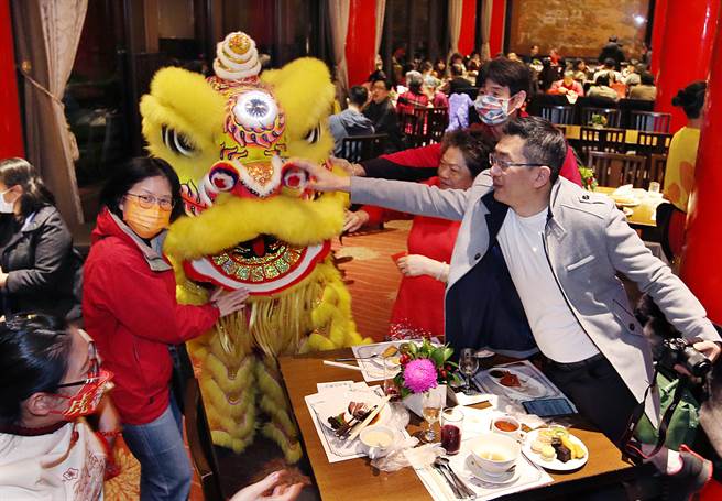 31日农历年除夕夜，不少家庭选择在台北圆山饭店围炉吃年夜饭，民眾争相与舞狮合影并摸狮头分享好彩头。（姚志平摄）