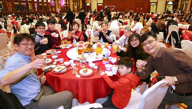 31日农历年除夕夜，不少家庭选择在台北圆山饭店围炉吃年夜饭，民眾争相与舞狮合影并摸狮头分享好彩头。（姚志平摄）