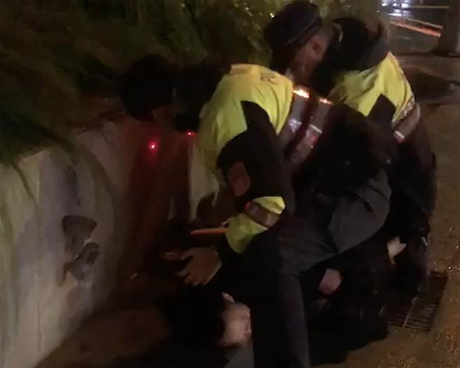 只因路過車輛播放的歌曲，男子怒砸車，文正派出所員警到場，男子仍然暴怒，警方只得將他壓制。（民眾提供／黃國峰台中傳真）