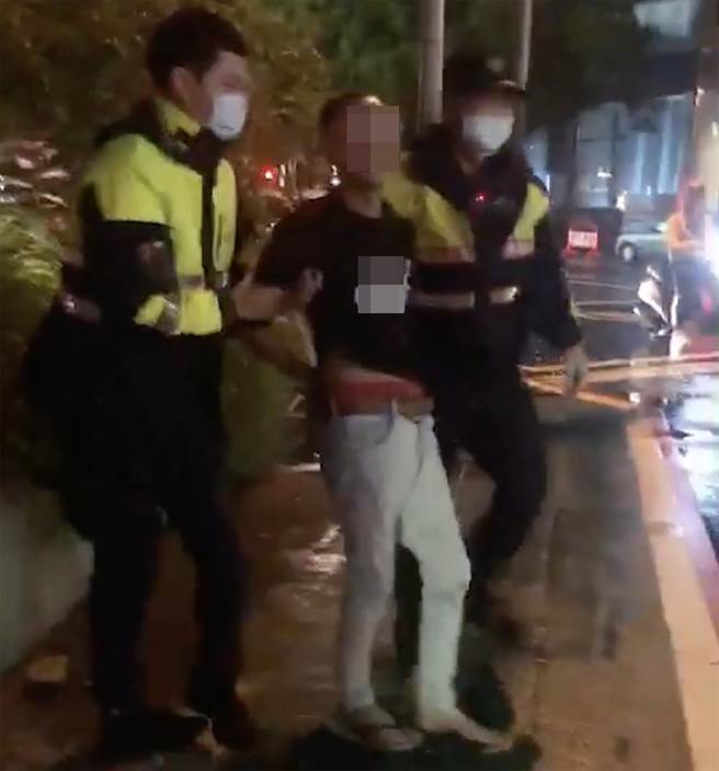 只因路過車輛播放的歌曲，男子怒砸車，文正派出所員警到場，男子仍然暴怒，警方只得將他壓制上銬，帶回所偵辦。（民眾提供／黃國峰台中傳真）