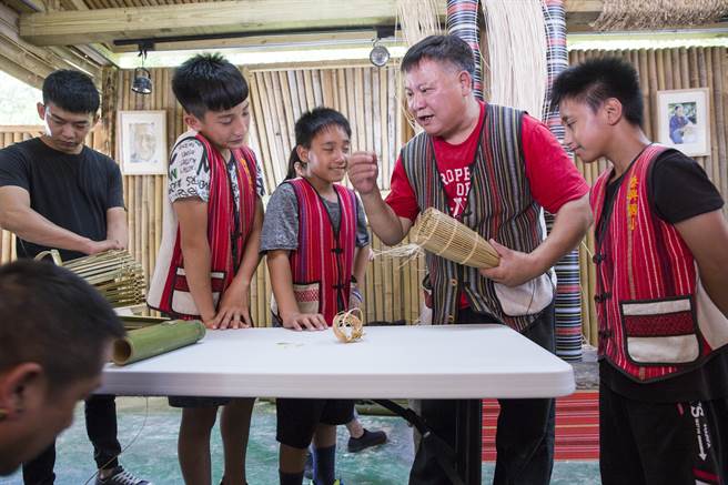 李永成（右二）之前在泰興國小擔任文化指導員，與族裡耆老共同教授各項傳統技藝，他向學生解說魚筌的編法。（黃子明攝）