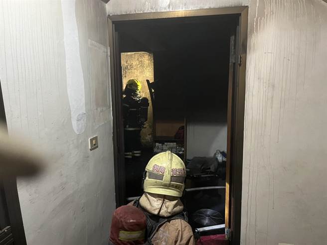 台南永康区一处公寓4楼发生火警，13分钟扑灭火势，消防人员进入烧毁的屋内救灾。（台南消防局提供）