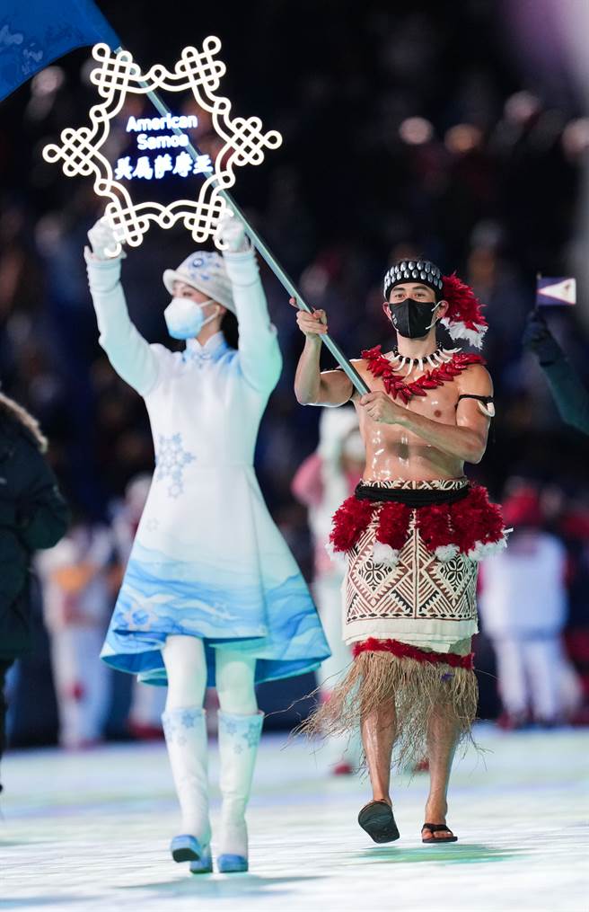 在北京室外體育場的零下攝氏度氣溫下，美屬薩摩亞旗手（右）赤裸著上半身。（圖／新華社）