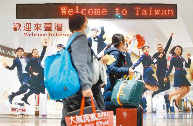 中央流行疫情指挥中心4日公布国内新增71例新冠肺炎确定病例，分别为25例本土个案及46例境外移入，在桃园机场入境管制区内，刚下机的旅客准备通关入境（图中非新闻当事人）。（范扬光摄）