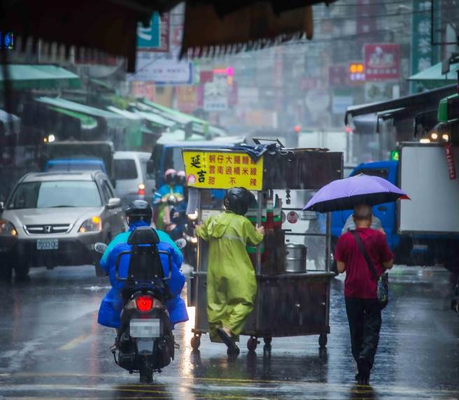 本土疫情趨於穩定，台北市長柯文哲7日談及北市微解封議題時表示，要觀察一個禮拜，OK的話從人流管制慢慢放鬆，跟民生經濟無關的先慢慢放。圖為攤商冒著大雨為生計努力。(示意圖，羅永銘攝）