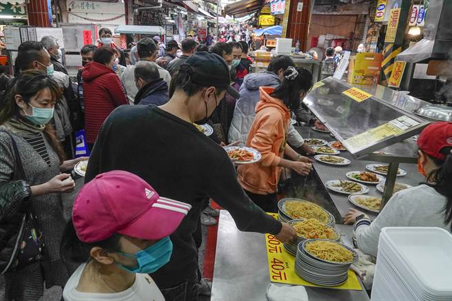 金山老街知名美食店吸引许多饕客前往品尝美味，大家虽然排队，但许多人仍挤在摊位旁争先拿菜。（黄子明摄）