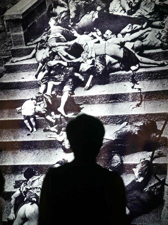 北京中国人民抗日战争纪念馆中一名参观者在重庆大轰炸的照片前驻足观看。（中新社）