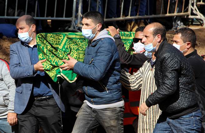 男童遗体被盖上一条写有古兰经的绿色被单，大批居民在距离墓地几公里之外宣读祈祷文致哀。 (图/路透社) 