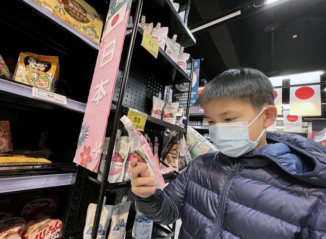 行政院8日宣告放寬日本福島周邊5縣市食品管制，引發各界關注爭議，民眾在購買日本進口食品時仔細地挑選。圖為新聞示意，圖中賣場並未販售福島災區食品。（范揚光攝）