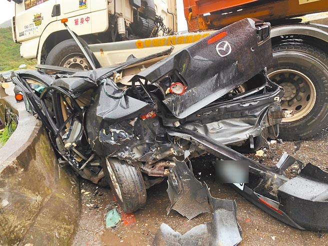 新北市瑞芳滨海公路7日发生重大死亡车祸，马自达3轿车与联结车对撞，马3驾驶夹困车内，救出后送医不治。（民眾提供／王扬杰新北传真）
