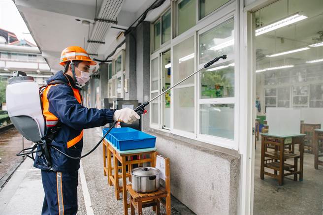新北市环保局人员9日前往新北市板桥国中喷洒消毒，确保校园环境卫生安全。(郭吉铨摄)