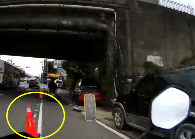 女骑士下桥后直直朝三角锥衝去，惨摔车倒地。（翻摄自脸书社团《爆废公设公开版》）