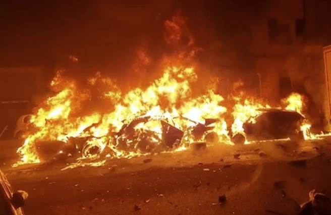 发生撞击后，肇事货车、数辆汽车和一栋房屋的外墙起火，当地消防员扑灭火势并疏散屋内居民。 (图/美联社) 