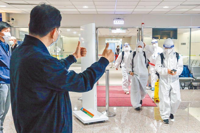 踢完印度亚洲杯的中华女足搭乘华航专机返台，落地採检阴性的成员步出候机室时，有机场人员竖起大姆指为他们加油打气。（陈麒全摄）