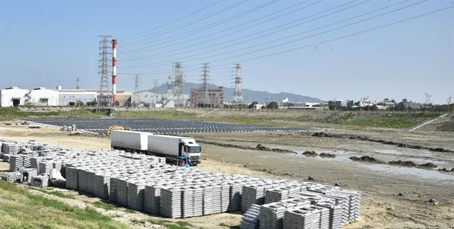 高雄市水利局工作人员正在为冈山五甲尾滞洪池建置光电板作业，未来预计每年可发674万度电。（林瑞益摄）