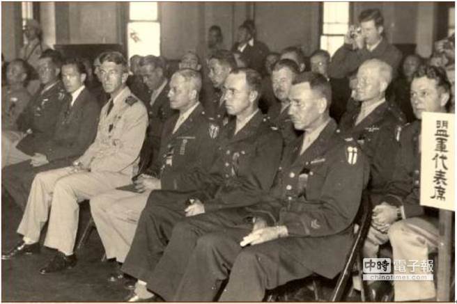 1945年10月25日受降典礼盟军代表席，其中包括了杜鲁门总统的私人代表洛克（前牌左三着西装者）。前排右一（据判断）为联络组长顾德理上校 ，他军装左袖上的两个箭头符，代表他有在海外服务两年的资歷。依年龄看来，右二应该是联络组参谋长柏克上校（40岁），但不知何因，他没有驻华美军的臂章，按照当天的签名簿，右三这位上校可能是Col Holly。按照签名的顺序及官阶，作者判断二排右一可能是艾文思。（照片来源：网路，炳文提供）