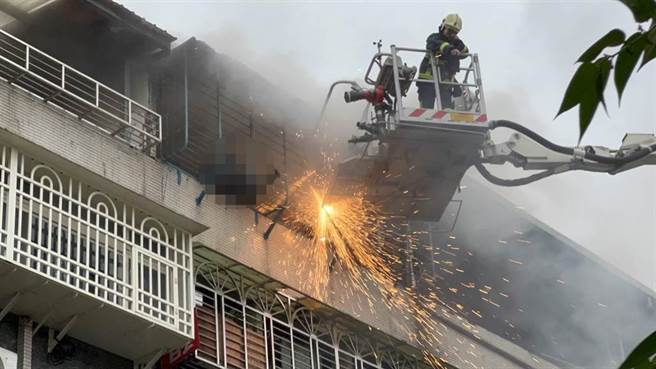 新庄区自立街公寓民宅火警，75岁蔡男受困5楼阳台铁窗，无奈火势过猛，消防员获报后破门抢救，蔡男在窗边已成焦尸，详细起火原因仍待调查。（戴上容摄）