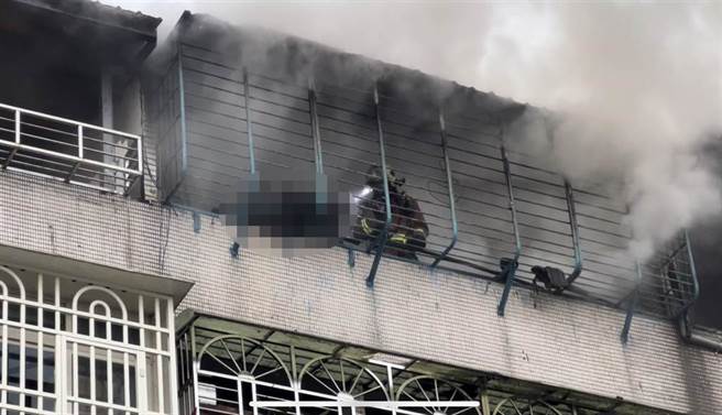 新庄区自立街公寓民宅火警，75岁蔡男受困5楼阳台铁窗，无奈火势过猛，消防员获报后破门抢救，蔡男在窗边已成焦尸，详细起火原因仍待调查。（戴上容摄）