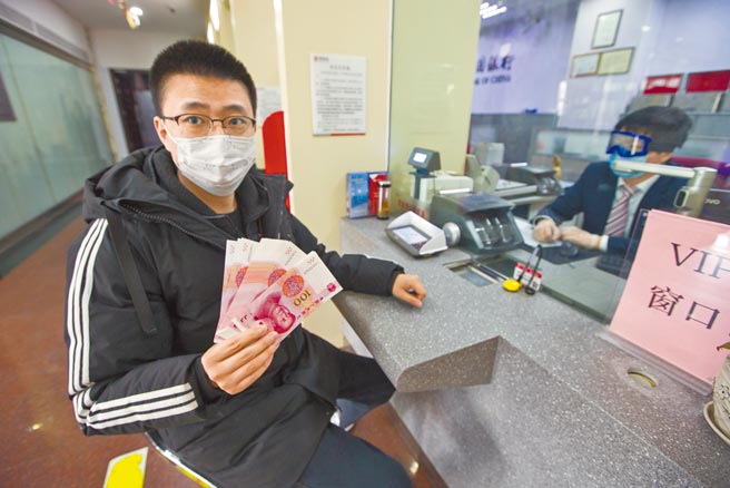 为进一步防治洗钱，大陆3月1日起个人存取现金超5万元需登记资金来源。图为山西太原一银行，民眾展示刚刚取出的全新人民币。（中新社）