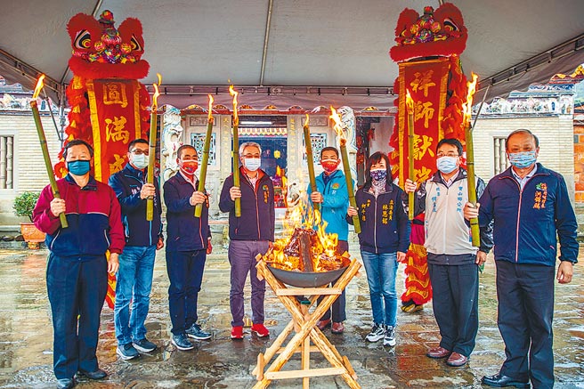 新竹县北埔乡「正月十五油笐火」元宵系列活动12日展开，乡长庄明增（中左）与地方人士共同点起油笐火，象徵薪火相传，强调今年活动风雨无阻举办。（罗浚滨摄）