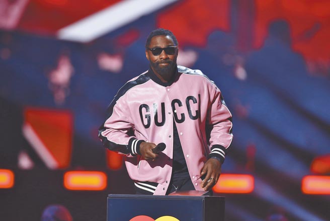伊卓瑞斯艾巴身穿粉色Gucci粉色飞行员夹克宣布年度专辑得奖者。（美联社）