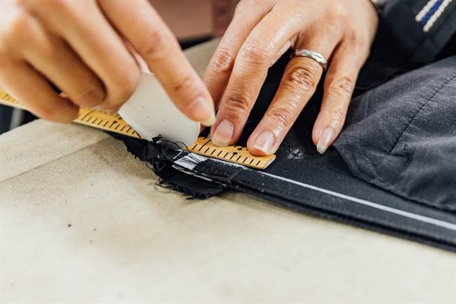 订制师在布面精准画出符合订制需求的线条，让后续剪裁、打版的流程更加顺利。（摄影／林冠良）