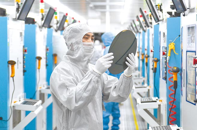 德国智库「外交政策协会」最近发布报告称，晶片的工业化生产集中在亚洲企业手中：韩国三星、日本东芝、台湾台积电，而台积电在最先进晶片的生产中更占据领先地位。图为浙江省嘉兴市嘉善县的一家科技公司内，工作人员在查看晶圆。（中新社）