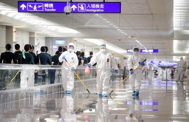 在桃园机场入境管制区内，身穿防护衣的清洁人员正在消毒入境长廊。（范扬光摄）（图中非新闻当事人）
