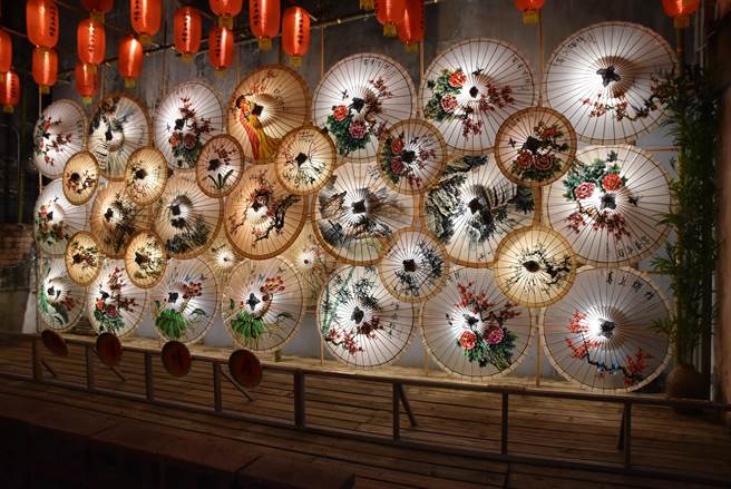 巷弄灯区邀请在地文史工作艺术家蔡享润以油纸伞、花布伞创作，取「伞」谐音祈盼疫情快快退散。（周丽兰摄）