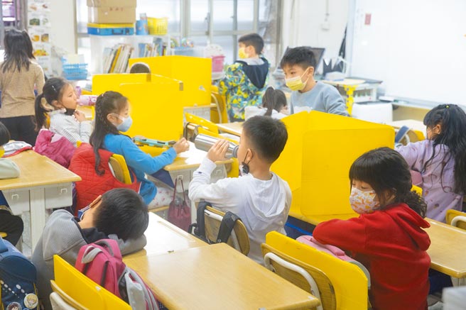 台北市大佳国小11日开学，为因应疫情，学生在教室内喝水需先将隔板立起，才能脱下口罩。（杜宜谙摄）