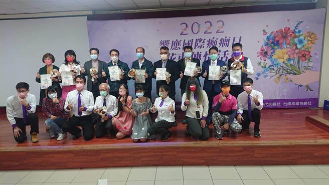 台南市癫痫症病友与癫痫之友协会前理事长蔡景仁（前排）在情人节也是国际癫痫日前夕献花给包括台南市长黄伟哲（后排左四）在内的支持者与照护者（后排），表达感谢。（程炳璋摄）