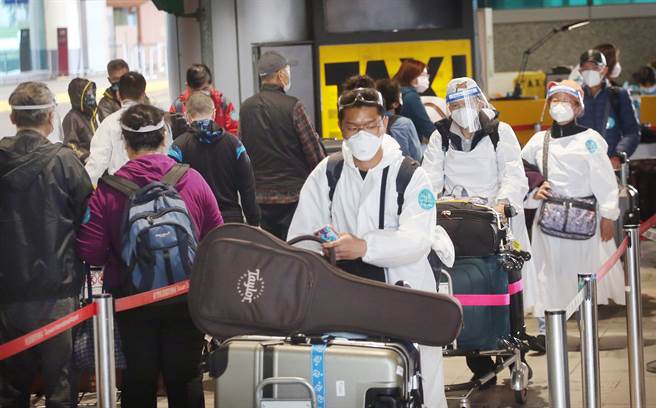 指挥中心澄清新北手摇饮店员确诊，序列是与桃机有关。图为入境旅客排队搭乘防疫计程车。（范扬光摄）