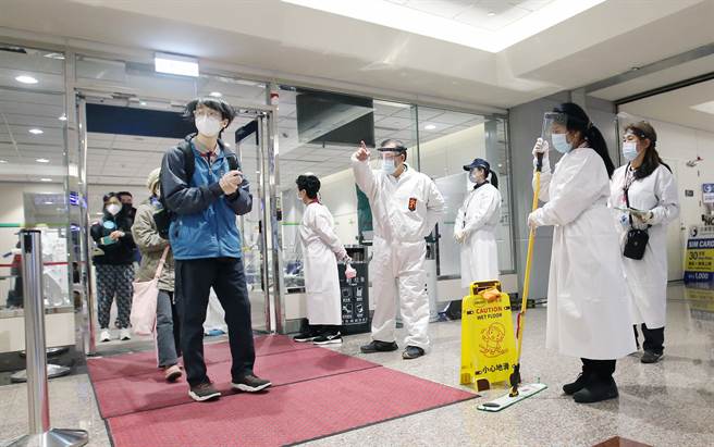 衛福部長陳時中宣布，研擬縮短入境旅客的居家檢疫天數，預計從現行14天縮短為10天，最快三月中實施。圖桃園機場落地採檢為陰性的旅客準備通關入境，身穿防護衣的清潔人員在旁待命消毒環境。（范揚光攝）