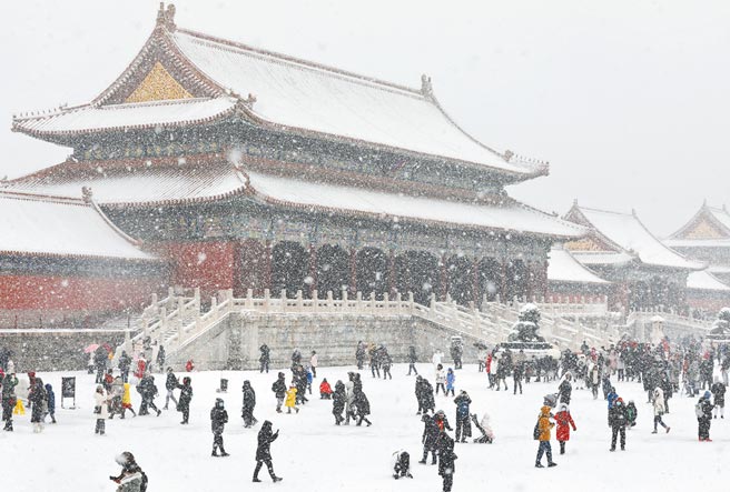 北京13日下起大雪，气象台发出暴雪黄色预警。图为游客到北京故宫赏雪。（新华社）