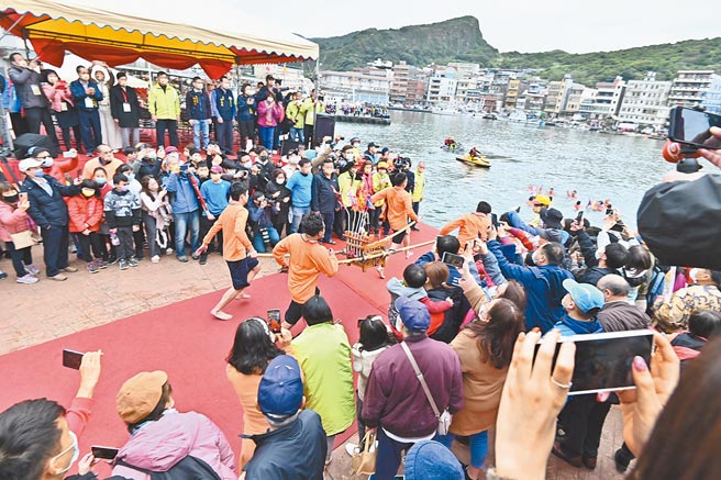 抬轿勇士抬着神轿跳入港中，再赤脚踏过炭火，祈求神威庇佑。（新北市万里区公所提供／王扬杰新北传真）