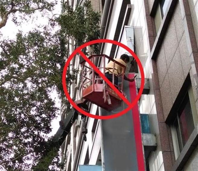 （使用移动式起重机搭乘设备未配戴安全帽及安全带。图／北市劳动局提供）