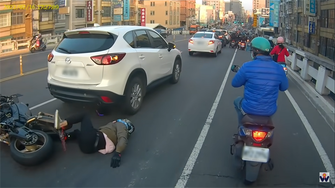 一辆红牌重机骑士衝上陆桥后，惨撞上前车屁股，摔倒在地。（翻摄YouTube频道「WoWtchout - 地图型行车影像分享平台」）