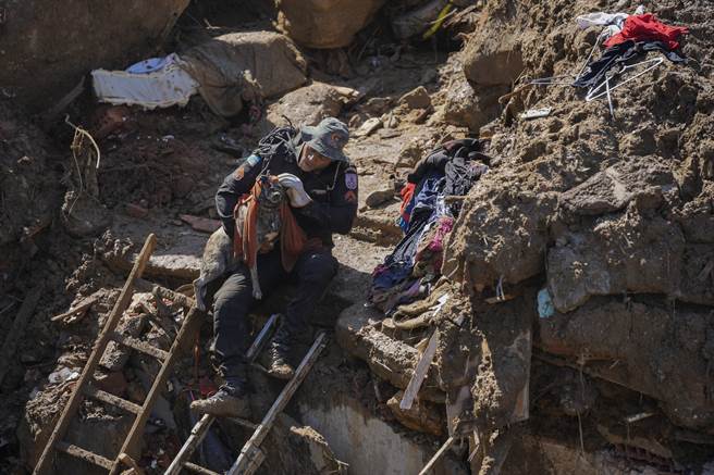 搜救人员带着工作犬找寻生还者。(图/美联社) 