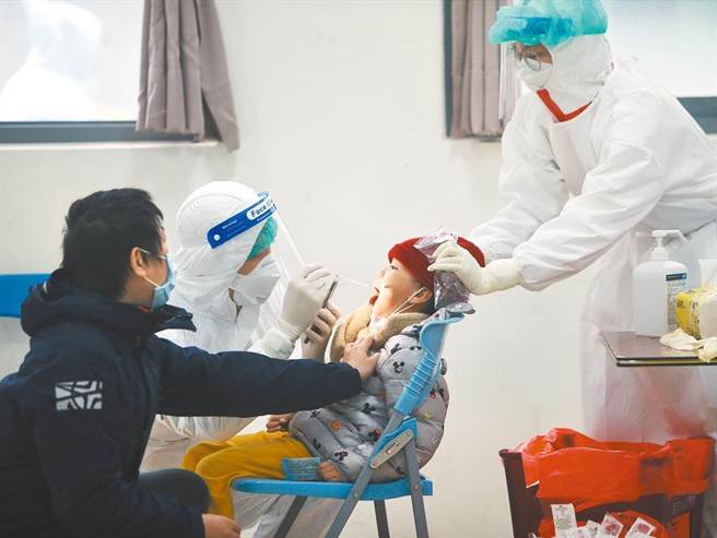 图为家长带着稚儿前往採检。（资料照／陈怡诚摄）
