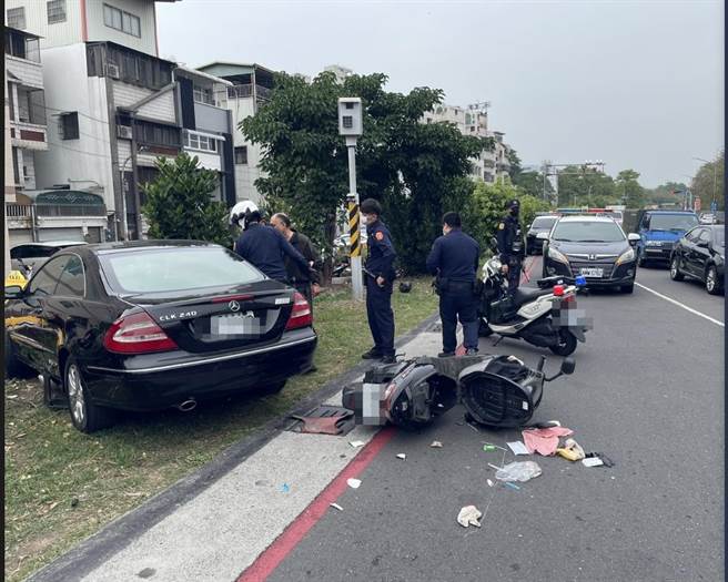 高雄賓士車衝至對向停等紅燈的機車，致2騎士手腳擦挫傷，賓士車卡在路邊行道樹停下，警方趕抵現場，發現賓士車主身上有濃厚酒味。（翻攝照片／石秀華高雄傳真）