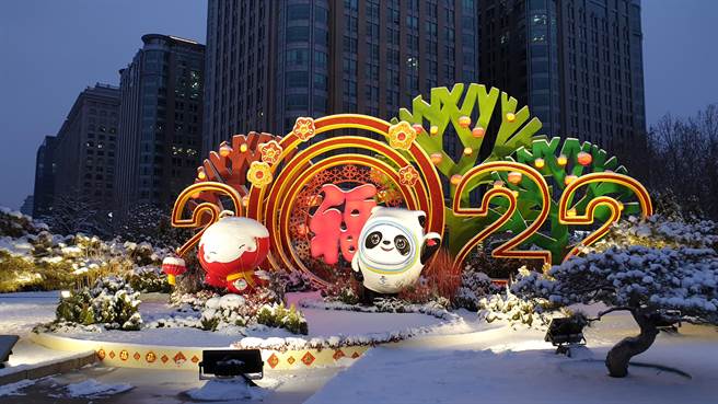 配色大量使用中国红加冰雪蓝，北京冬奥闭幕式将再次呈现中国式浪漫。图为冬奥吉祥物冰墩墩和冬残奥会雪容融，伫立在雪后的北京东单街头。（蓝孝威摄）