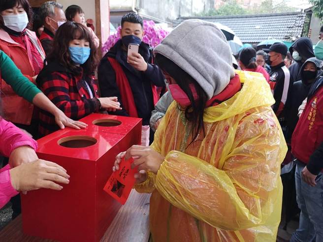 民眾抽出幸运红包，迫不及待打开。（庙方提供／王文吉台中传真）